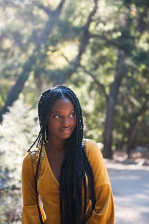 Fashion portrait of a woman in front of trees in the moutains
