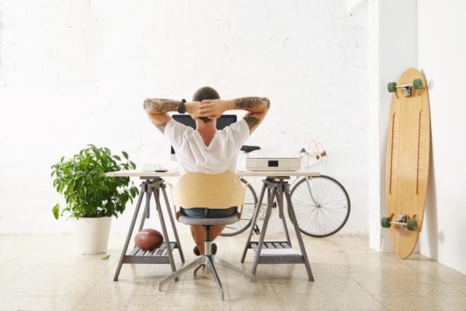 Read view of man staring at computer monitor in modern home office