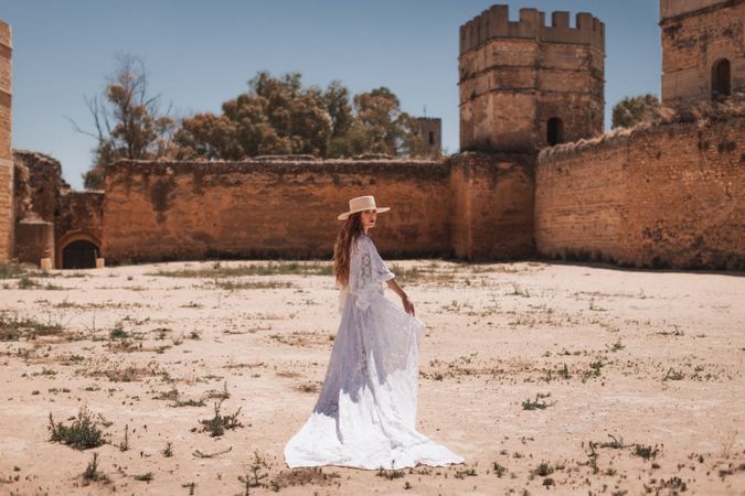 female standing by ruined castle