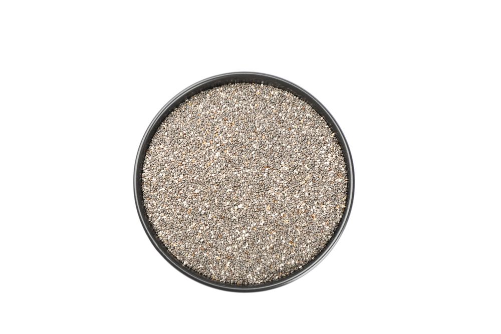 Chia seeds and bowl isolated on studio background