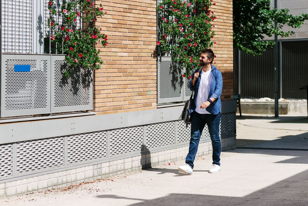 Man strolling next to windows with plants