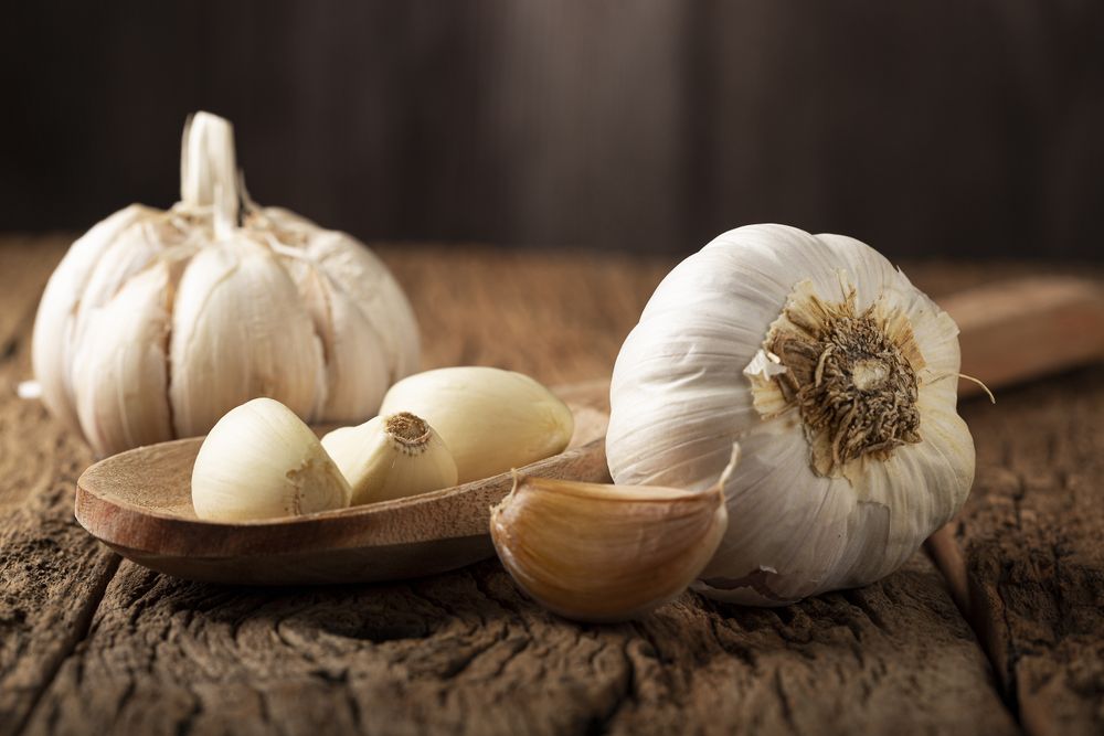 Garlic bulb and garlic cloves on the wooden table.