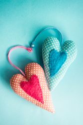 Felt heart ornaments on pastel blue background