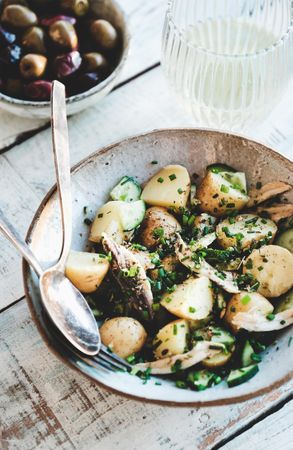 Greek style potato salad, olive bowl and wine, close up
