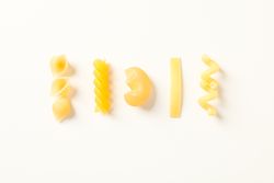 Flat lay composition with pasta on bright background, space for text