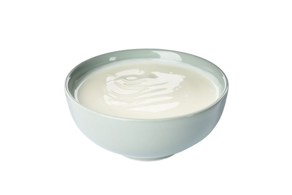 Bowl of sour cream yogurt isolated on light background