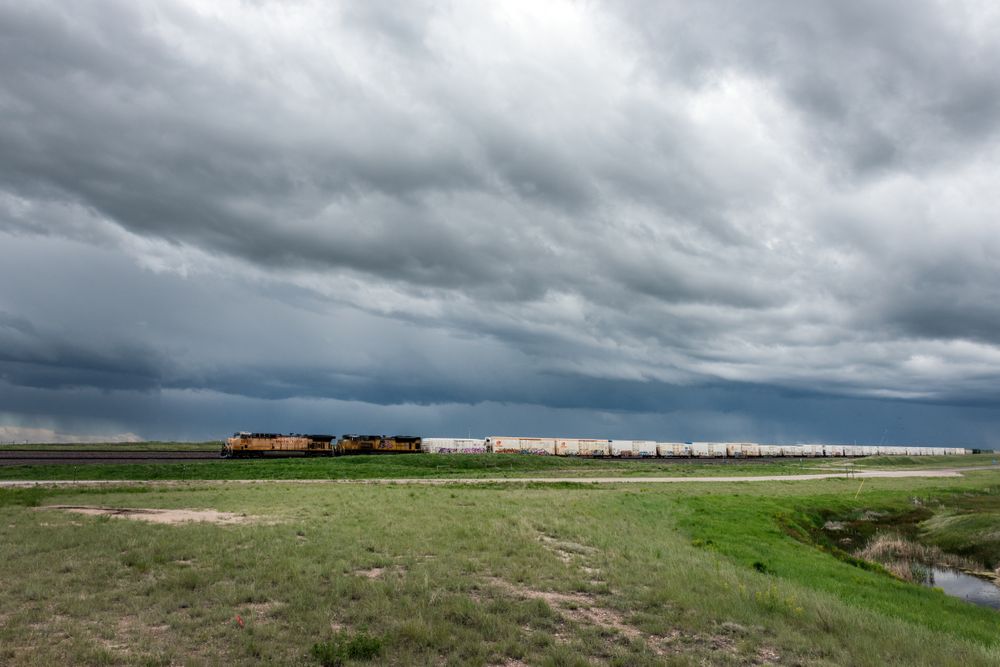 A freight train colorfully adorned with graffiti approaches Cheyenne, Wyoming