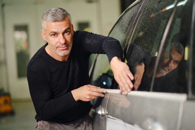 Mechanic putting protective tape on car