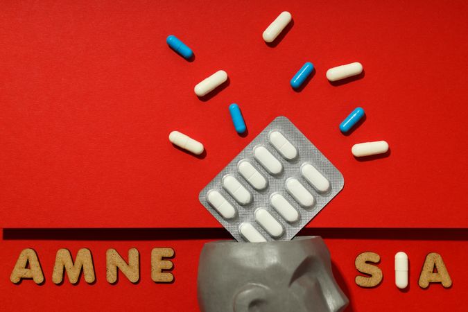 Close up of bust with pills and the words “Amnesia” copy space