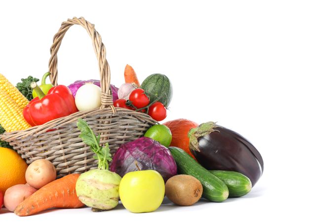 Wicker basket and different vegetables isolated on blank background