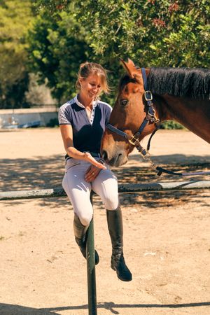 Content horsewoman with horse on paddock