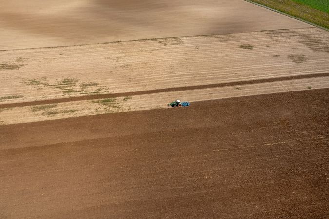 Drone shot of a tractor plowing an agricultural field in Germany