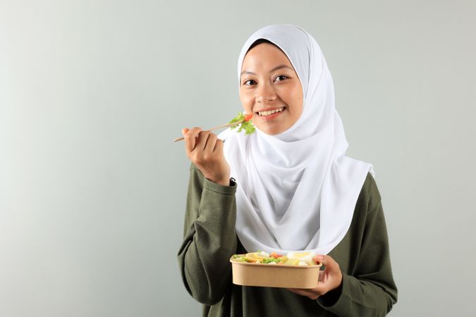 Asian Muslim Woman Wearing a Hijab Enjoys Eating Healthy Yummy Salad Bowl