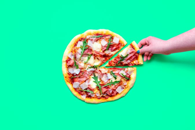 Prosciutto pizza above view, minimalist on a green background