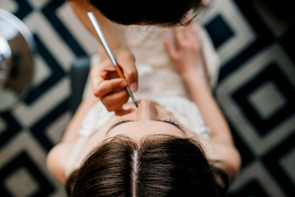 Top view of make-up artist putting make-up for a woman