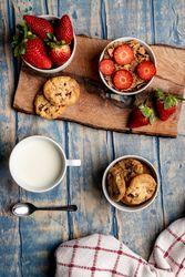 Glasses near fruits and cookies on table near napkin