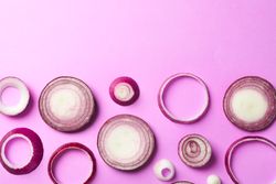 Flat lay composition with red onion rings on color background