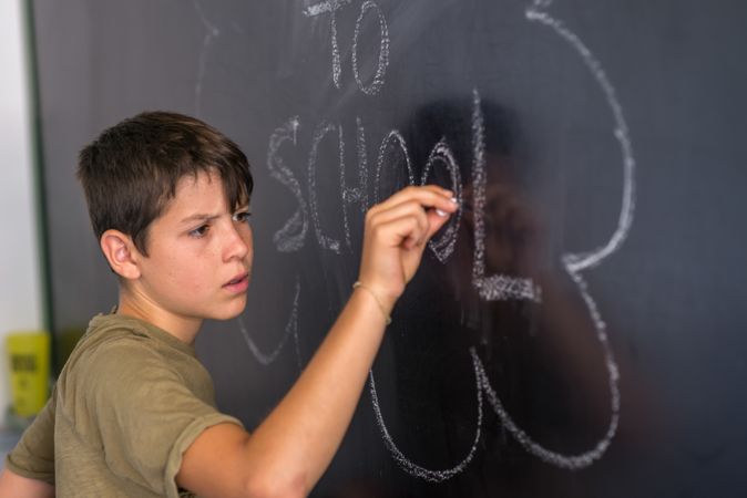 Teenager writing on chalkboard