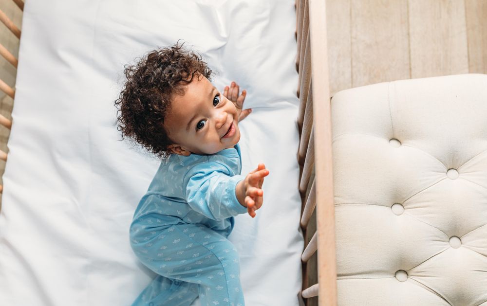 Cute baby boy looking up from crib