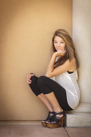 Portrait of Asian Woman Sitting On Pillar