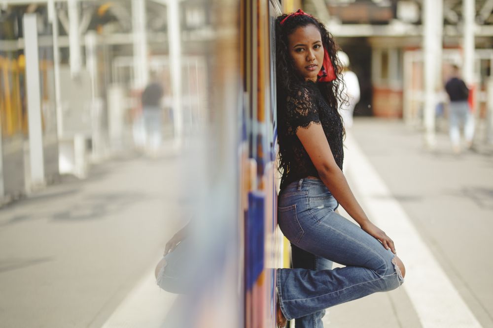 Cheerful hispanic woman standing on train