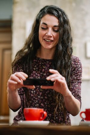 Brunette woman taking photo of coffee