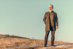 Man in brown coat standing on outdoor