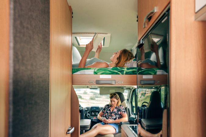 Females relaxing in motorhome bunk bed and back seat