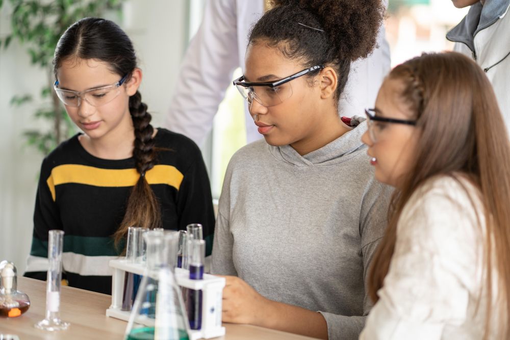 Female students in science class doing chemical experiment in laboratory