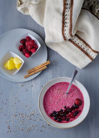Smoothie bowl with fresh berries and sesame served on table