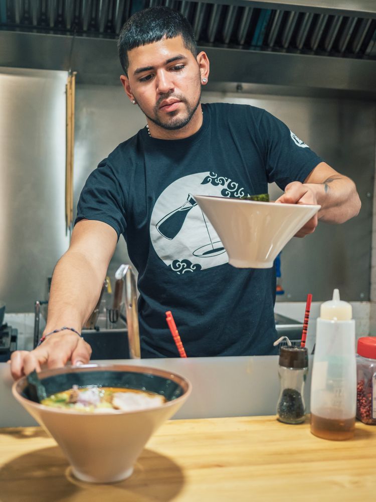 Male serving bowls with soup in restaurant