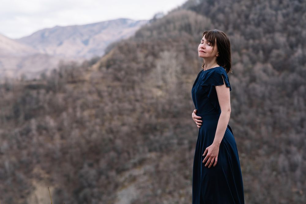 Woman in long blue dress standing in mountain