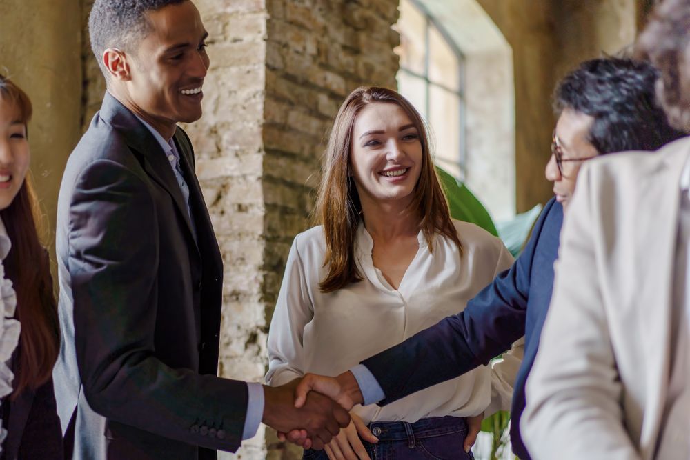 Multicultural office handshake celebration