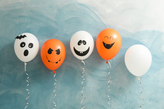Halloween balloons on color background, space for text