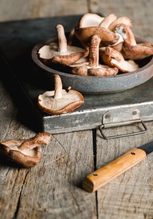 Pile of fresh brown mushrooms on rustic wooden table