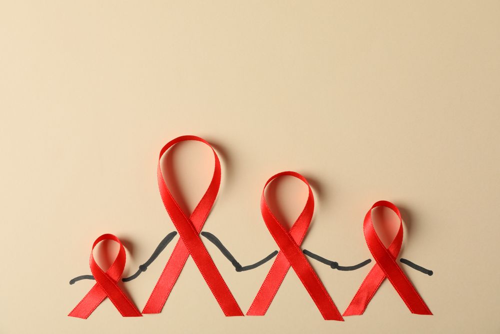 Awareness red ribbons on beige background, copy space