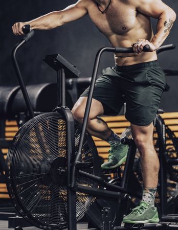 Hardworking male working out on gym bike
