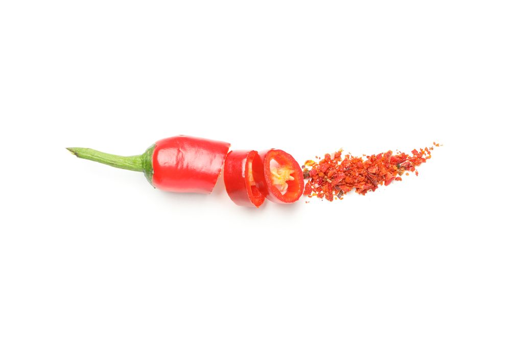 Chopped chilli pepper and spice isolated on plain background