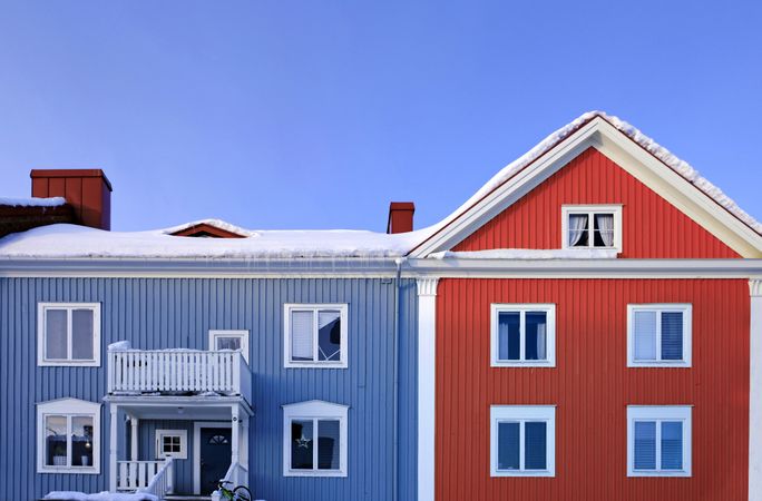 Blue and red cottage in winter countryside