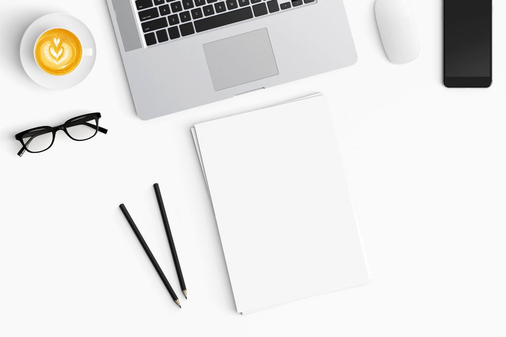 Modern workspace with coffee cup, smartphone, paper, notebook, tablet and laptop copy space