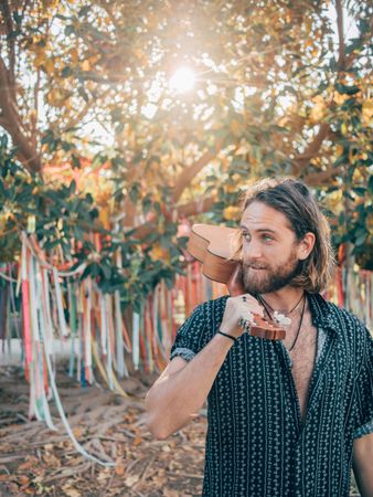 Hipster man in jungle with ukulele
