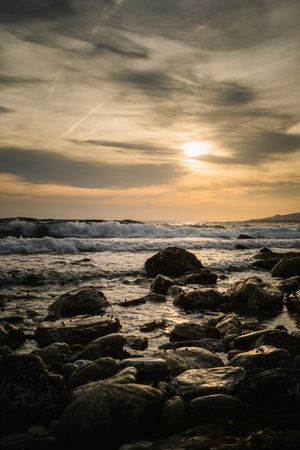 Stony seashore and waves at beautiful sunset