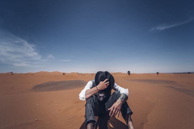 Anonymous cowboy sitting in desert