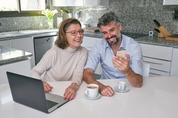 Happy mother with adult son having video call on smartphon