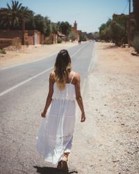 Woman in white dress walking in desert city