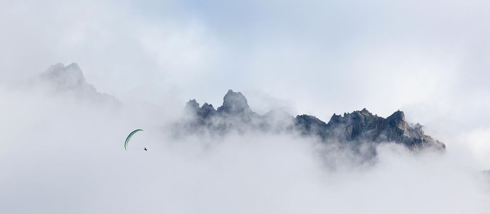 Person parachuting in cloudy sky