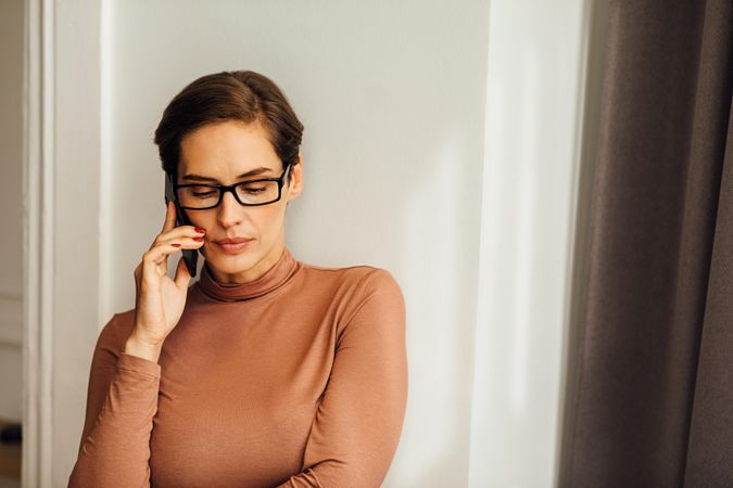 Woman looking down while on a phone call