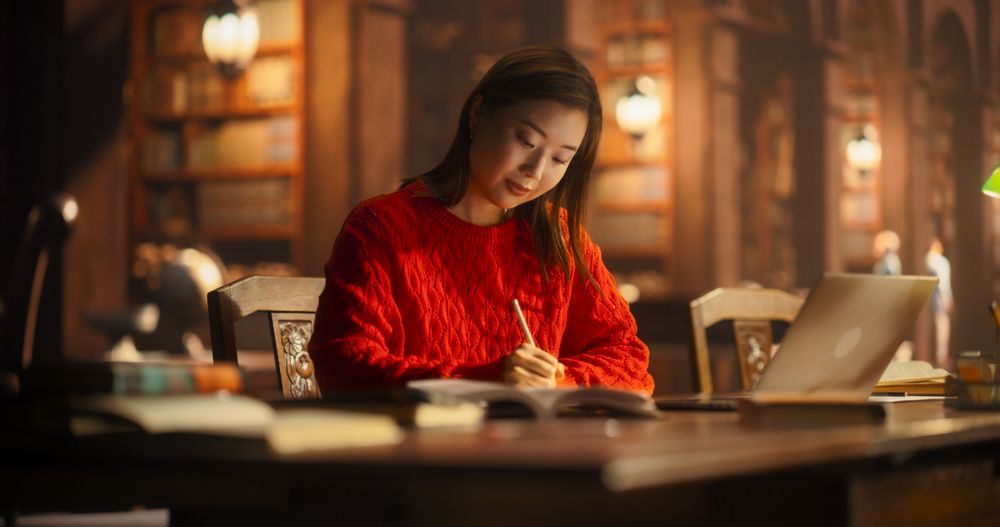 Diligent Asian Female Student Engaged in Academic Research in a Cozy Library