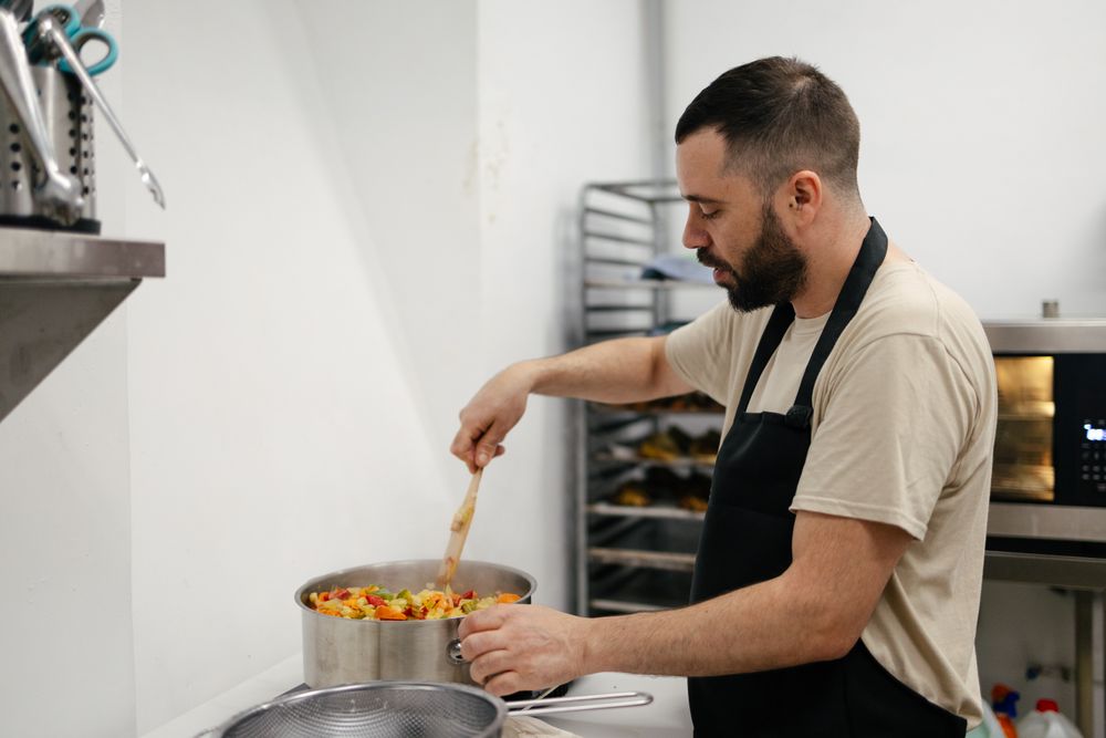 Young chef cooking with a casserole