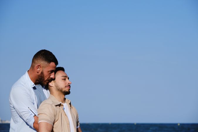 Male couple hugging on seaside